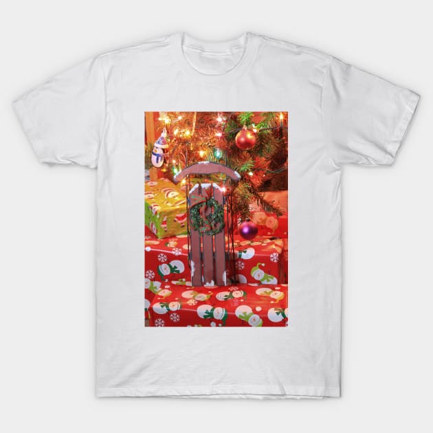 Christmas Sled with a Wreath on red presents under a Christmas tree T-Shirt by ROBERTDBROZEK